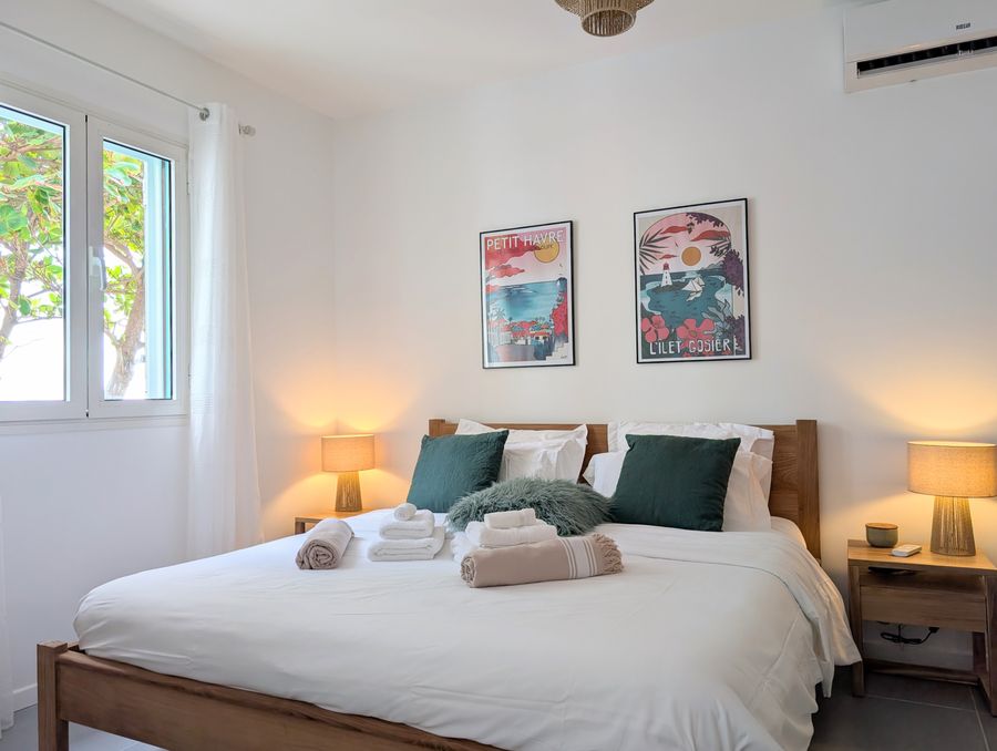 Affiches antillaises et linge de lit blanc — Villa Crystal Beach, Saint-François, Guadeloupe